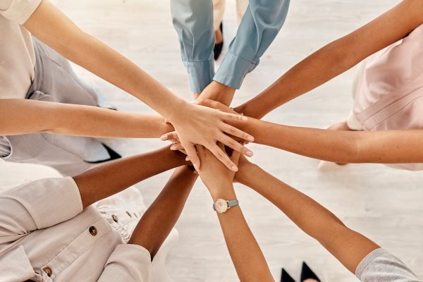 チームワーク:複数人が手を合わせるイラスト